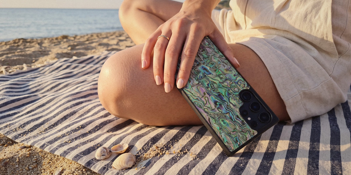 Green Abalone shell Samsung Galaxy case resting on a woman's knee at the beach