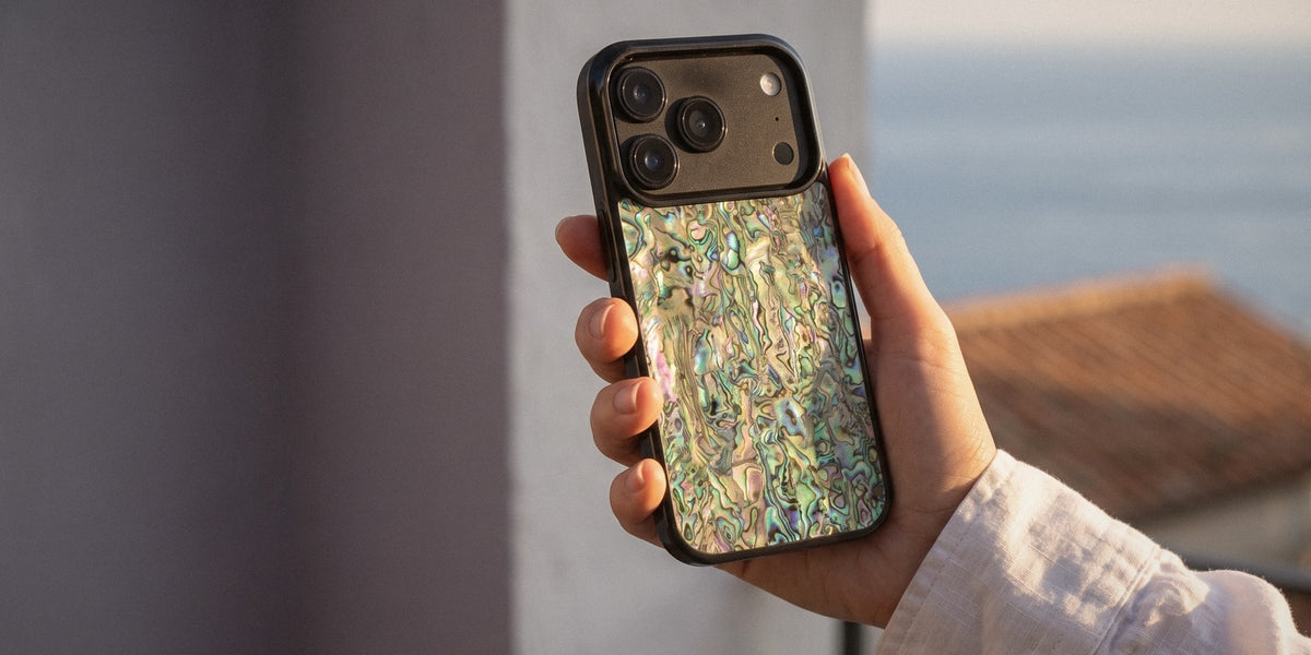 Green Abalone shell iPhone case held on a sunlit terrace